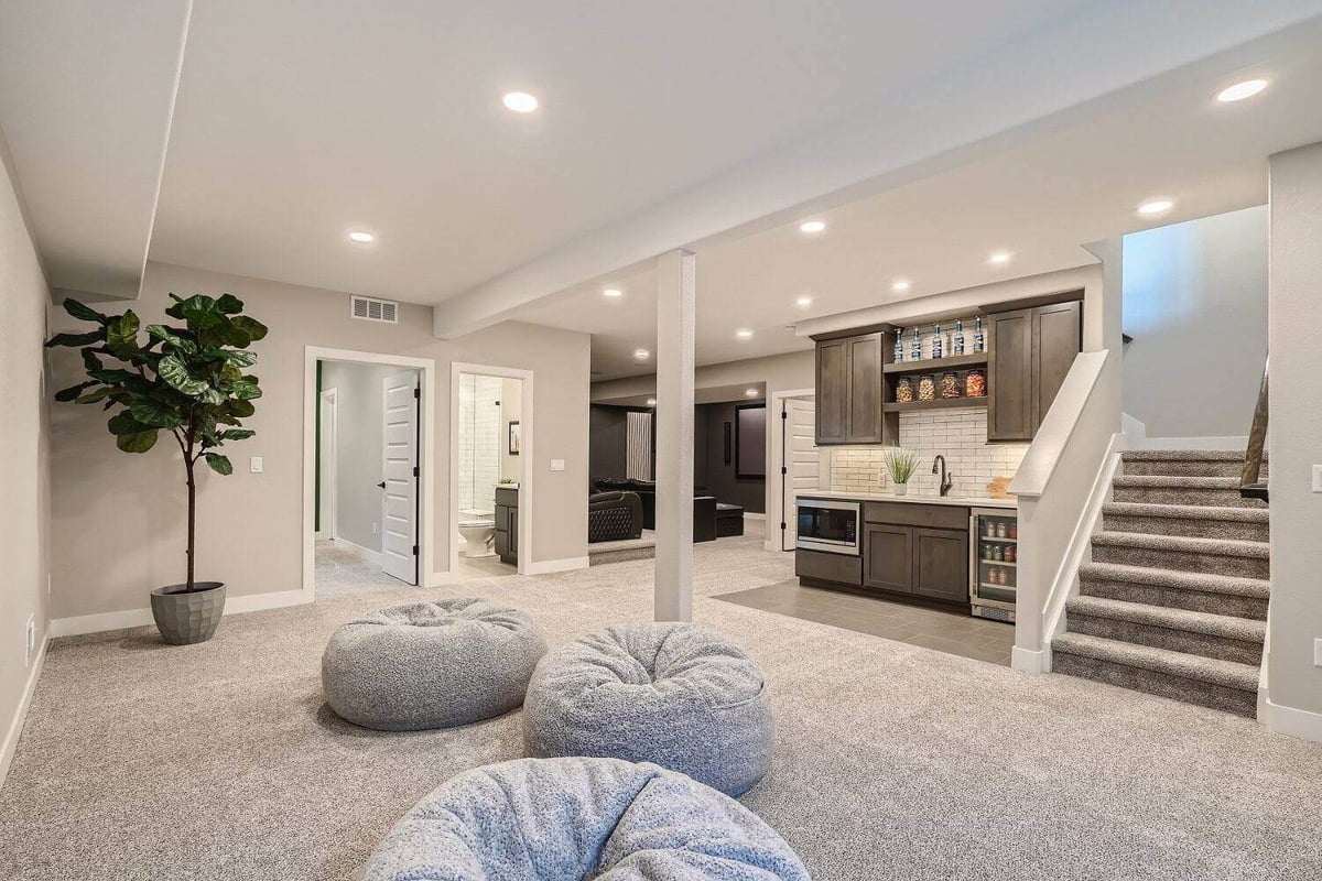 Lower-level family room with plush carpeting and TV, part of a basement renovation by Sheffield Homes in Arvada, CO