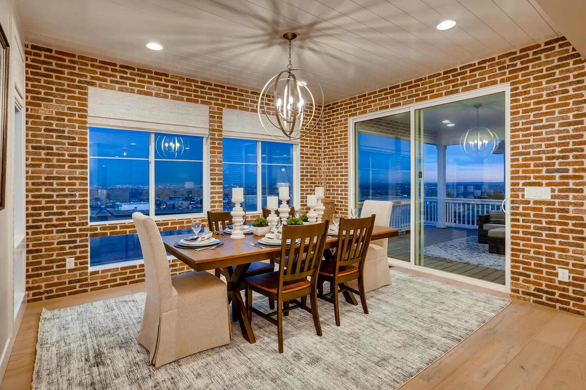 Dining room with brick accent wall in a custom home built by Sheffield Homes in Arvada, CO