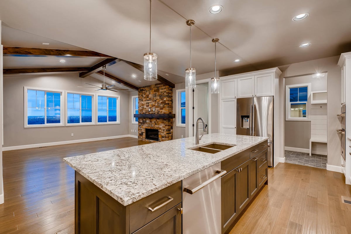 Close-up of stainless steel refrigerator and double ovens in a custom home by Sheffield Homes in Arvada, CO