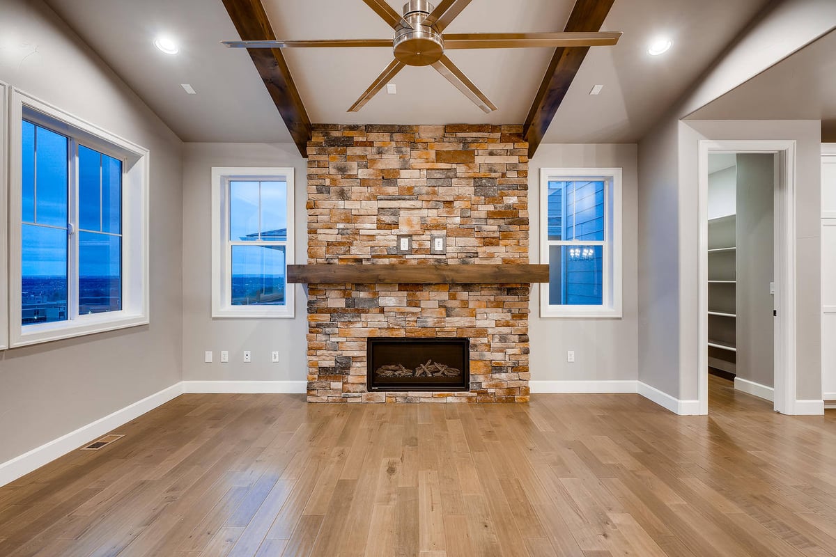 Cozy living room with stone fireplace in a custom home by Sheffield Homes in Arvada, CO