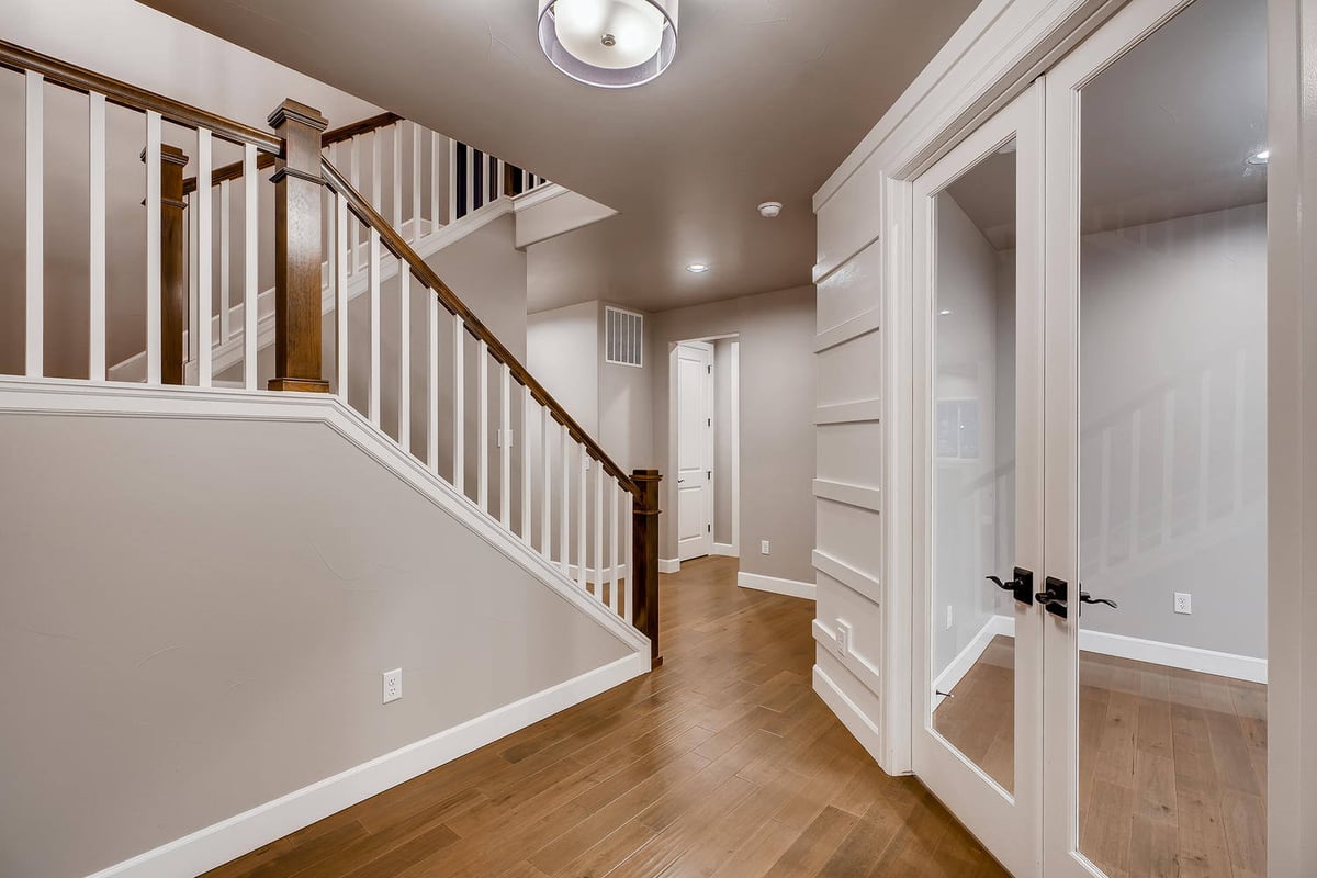 Entry foyer with wooden staircase in a custom home by Sheffield Homes in Arvada, CO