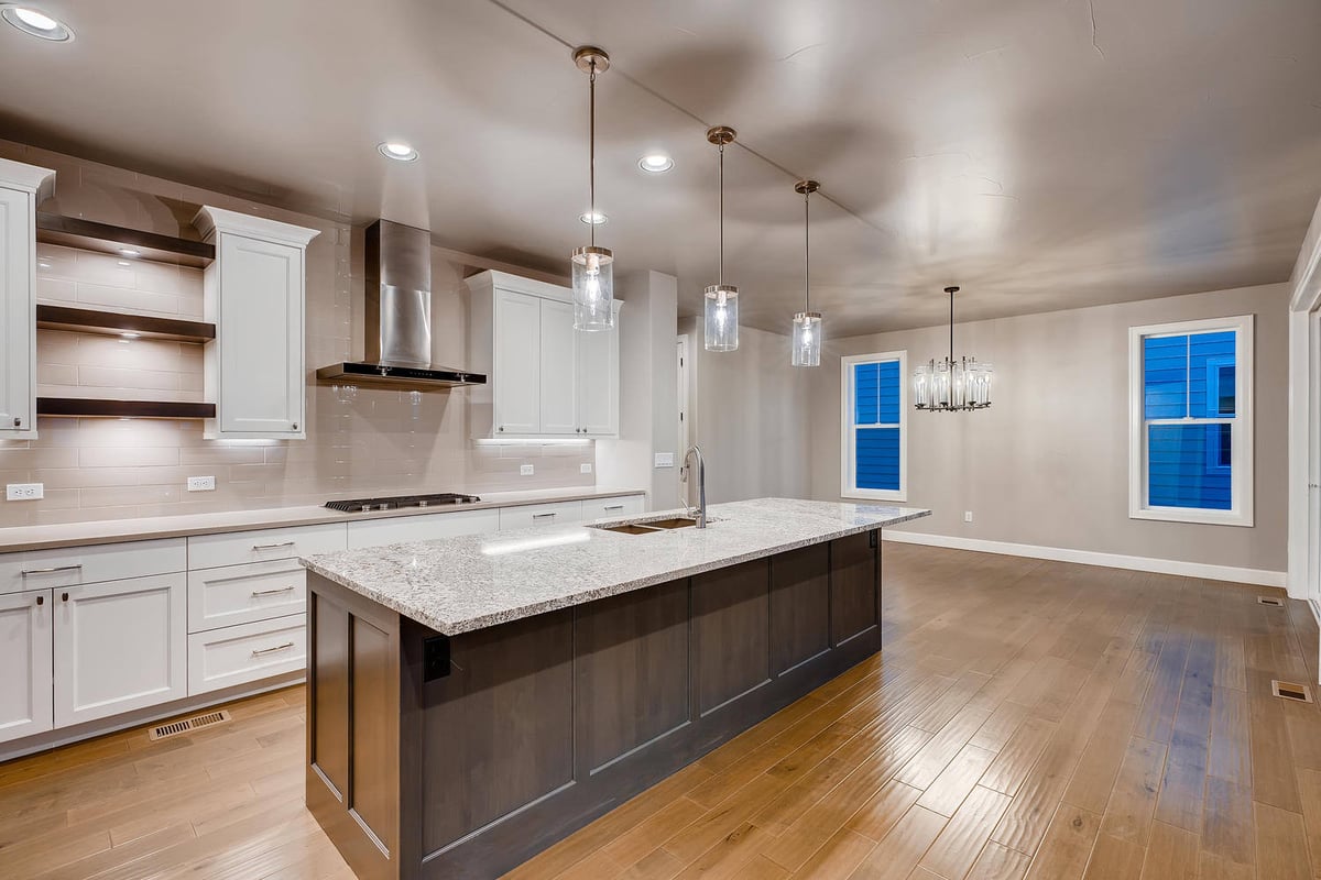 Kitchen with open shelving and stainless steel range hood in a custom home by Sheffield Homes in Arvada, CO