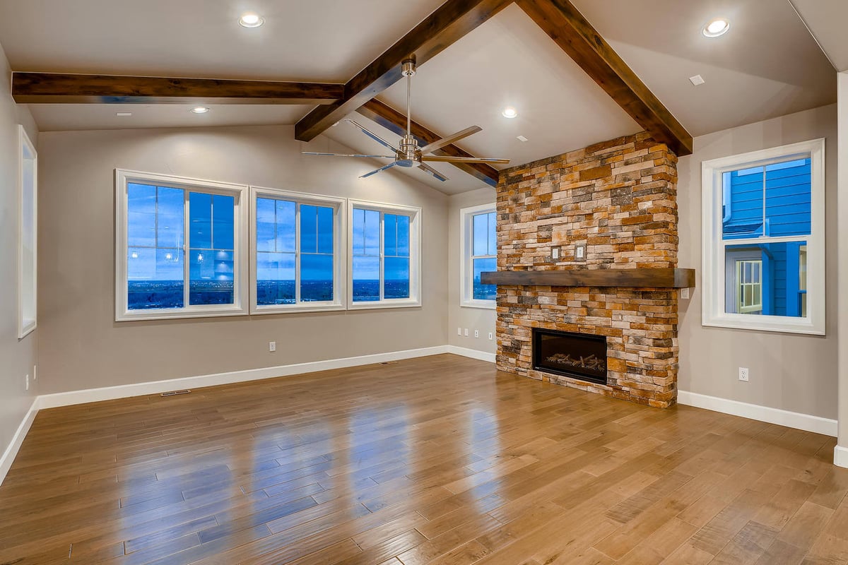 Living room with vaulted ceiling and stone fireplace in a custom home by Sheffield Homes in Arvada, CO