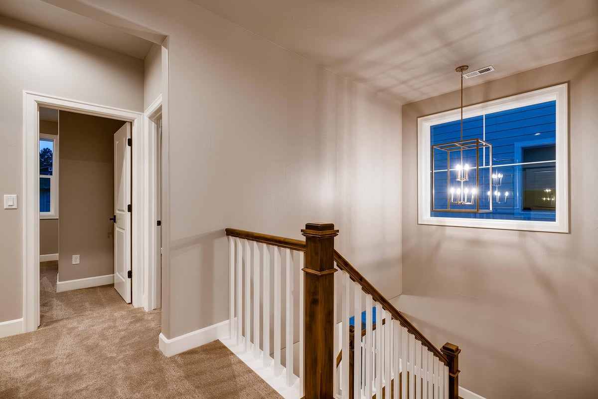 Second-floor landing with stylish chandelier in a custom home by Sheffield Homes in Arvada, CO