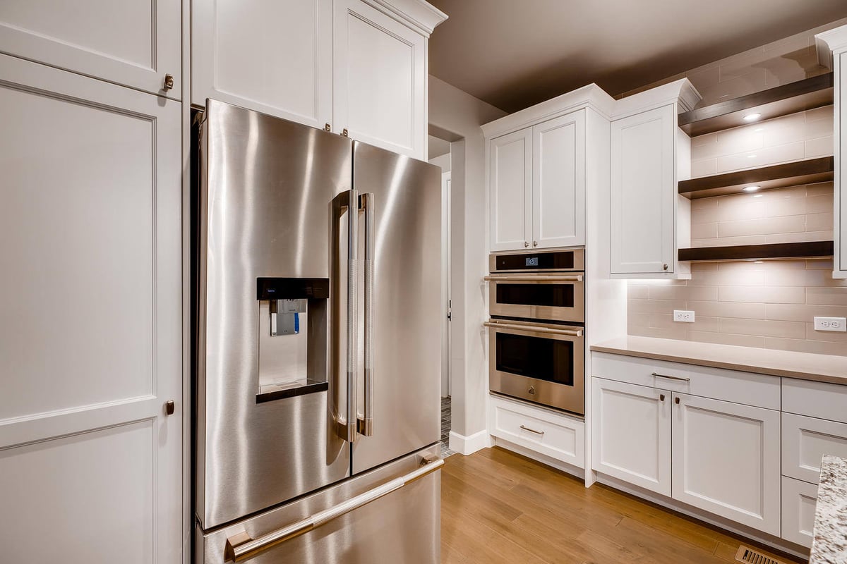 Spacious kitchen with island and stone fireplace view in a custom home by Sheffield Homes in Arvada, CO