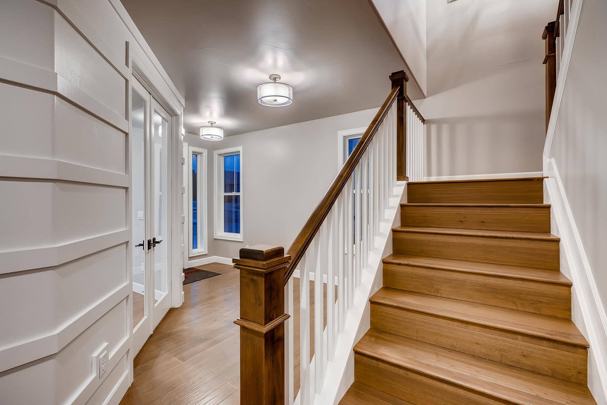 Wooden staircase with white railing in a custom home by Sheffield Homes in Arvada, CO