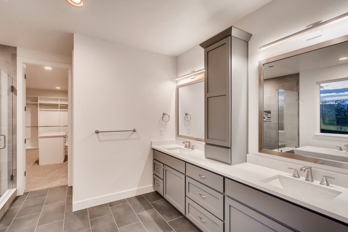 Custom primary bathroom with dual sinks and spacious walk-in closet in Arvada, CO by Sheffield Homes