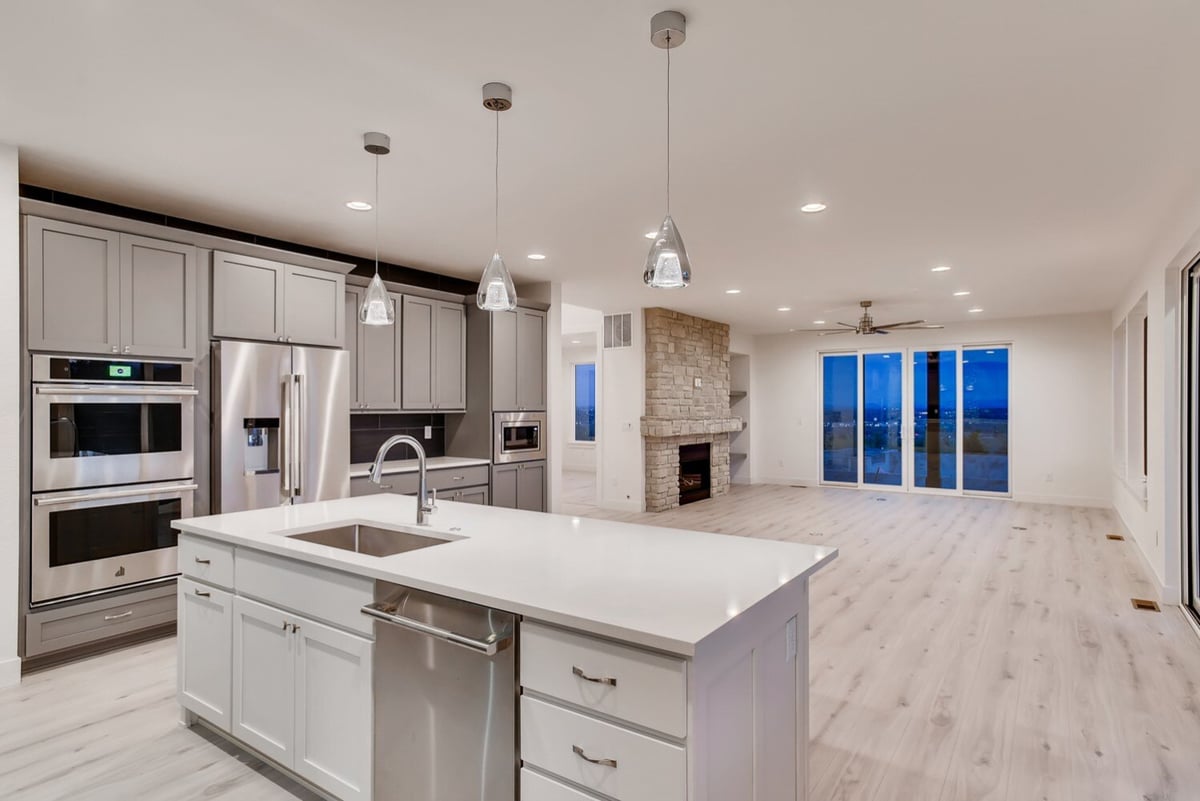 Kitchen with stainless steel appliances and island in a custom home by Sheffield Homes, Arvada, CO