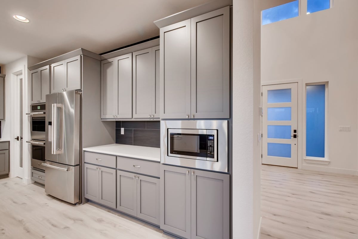 Modern kitchen in a Sheffield Homes custom home in Arvada, CO, with gray cabinetry and island