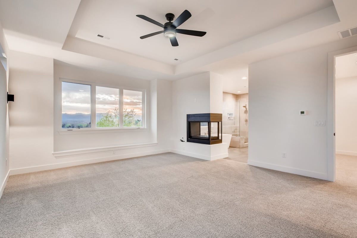 Primary bedroom with a ceiling fan and large window in a Sheffield Homes custom home, Arvada, CO