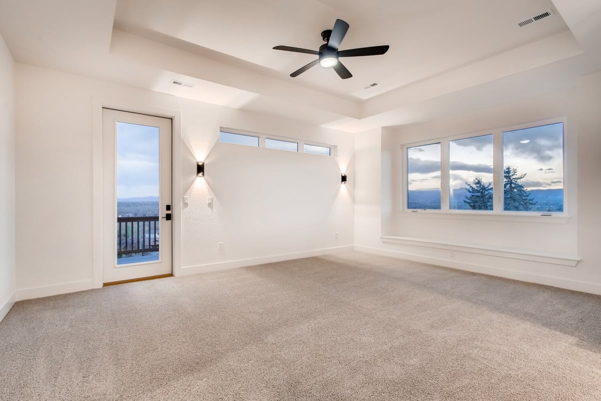 Primary bedroom with access to a private balcony in a custom home by Sheffield Homes, Arvada, CO