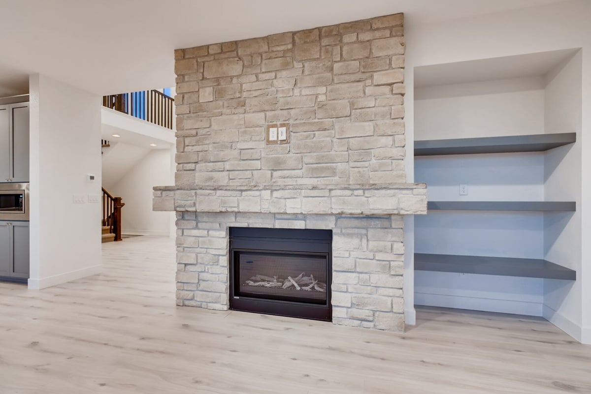 Stone fireplace with built-in shelving in a modern living room in Arvada, CO home