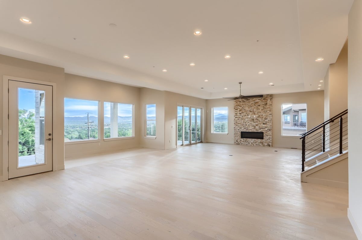 Bright lower level recreation room with large windows in a Sheffield Homes custom home in Arvada, CO