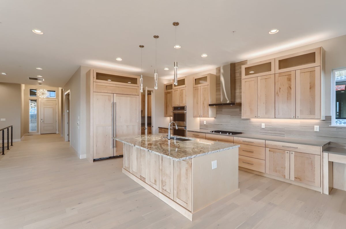 Elegant kitchen with wood cabinetry and a center island in a custom home by Sheffield Homes in Arvada, CO