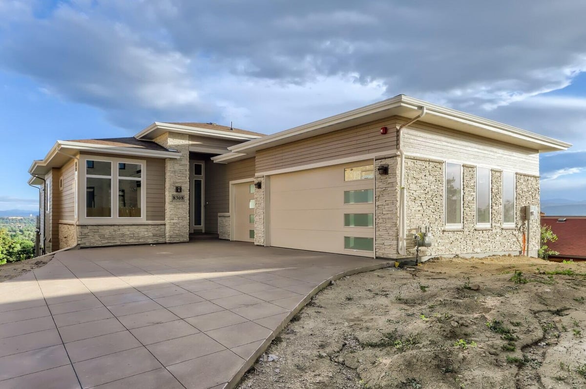 Front exterior view of a custom home with stone accents and modern garage doors by Sheffield Homes in Arvada, CO-1