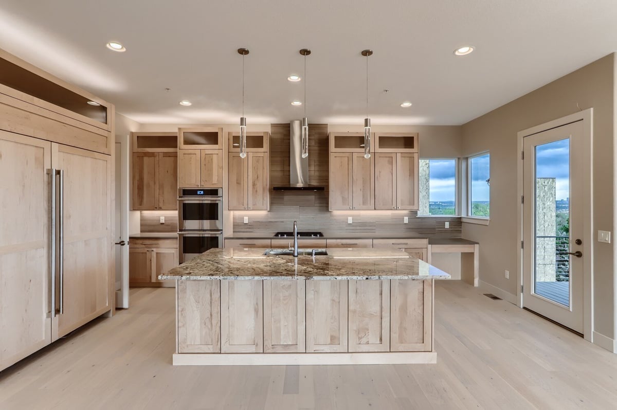 Modern kitchen with natural wood cabinets and stainless steel appliances in a Sheffield Homes project in Arvada, CO