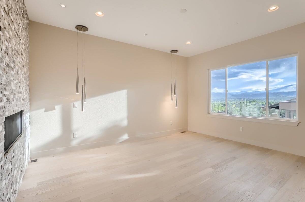 Primary bedroom with stone accent wall and pendant lights in a Sheffield Homes custom home in Arvada, CO