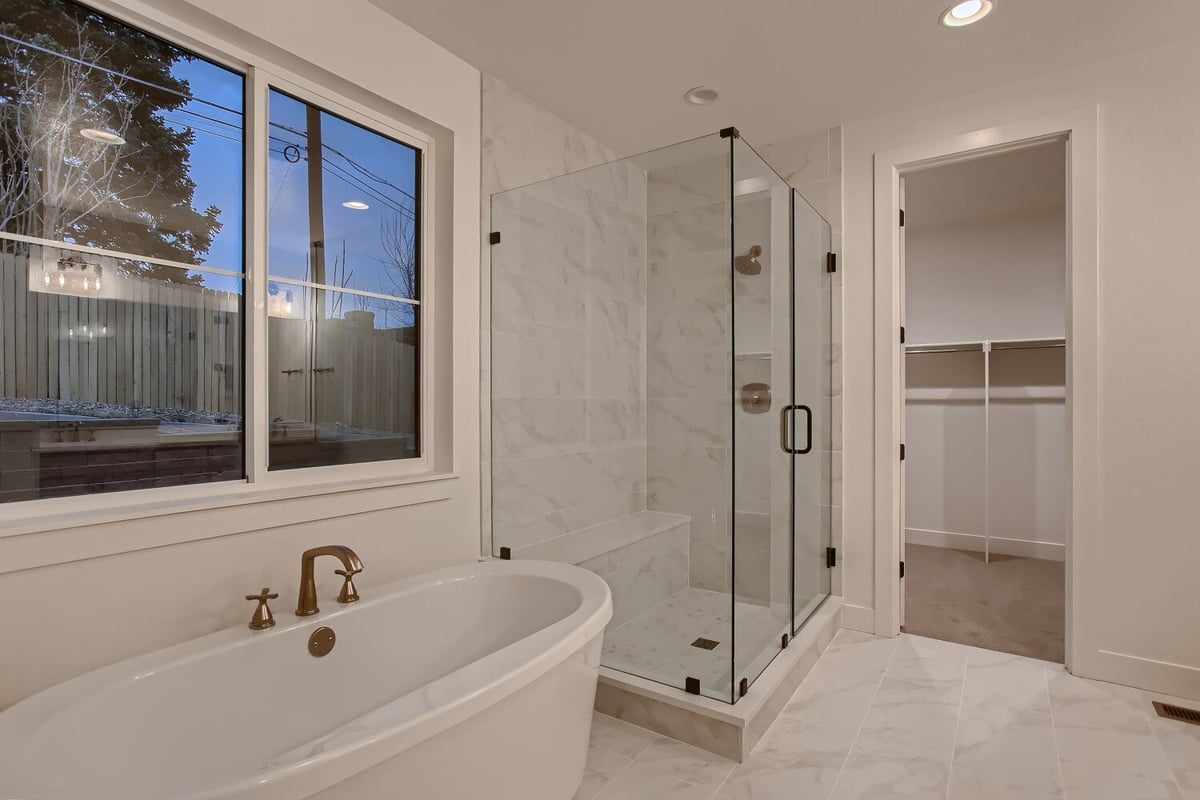 Premium bathroom with a shower room and bathtub beneath a window in a custom home by Sheffield Homes in Arvada, CO