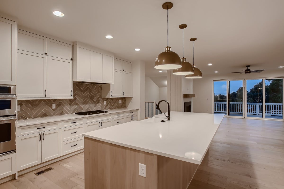 Second-floor kitchen with an island featuring a white top and wooden base in a custom home by Sheffield Homes, Arvada, CO