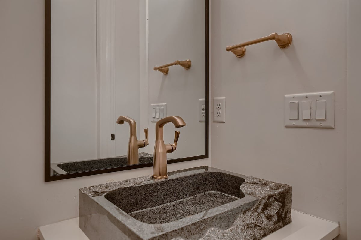 Closeup of a bathroom wash basin with a premium long bronze faucet in a custom home by Sheffield Homes in Arvada, CO