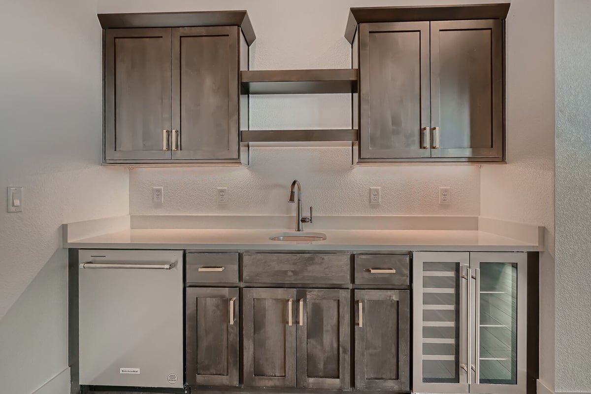 Front closeup of a lower-level wet bar with sleek, minimal colors in a house by Sheffield Homes in Arvada, CO