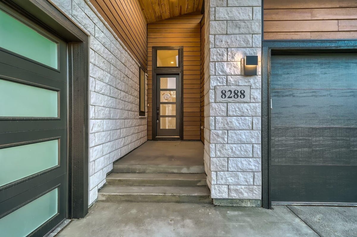 Front exterior view of the stone-designed entrance of a beautiful house by Sheffield Homes in Arvada, CO