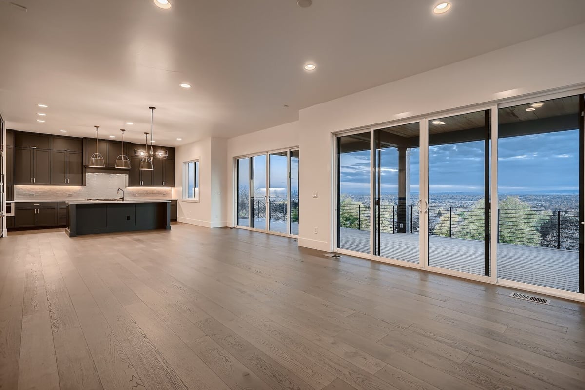Long shot of the living room with large sliding doors and an open kitchen in the corner by Sheffield Homes in Arvada, CO