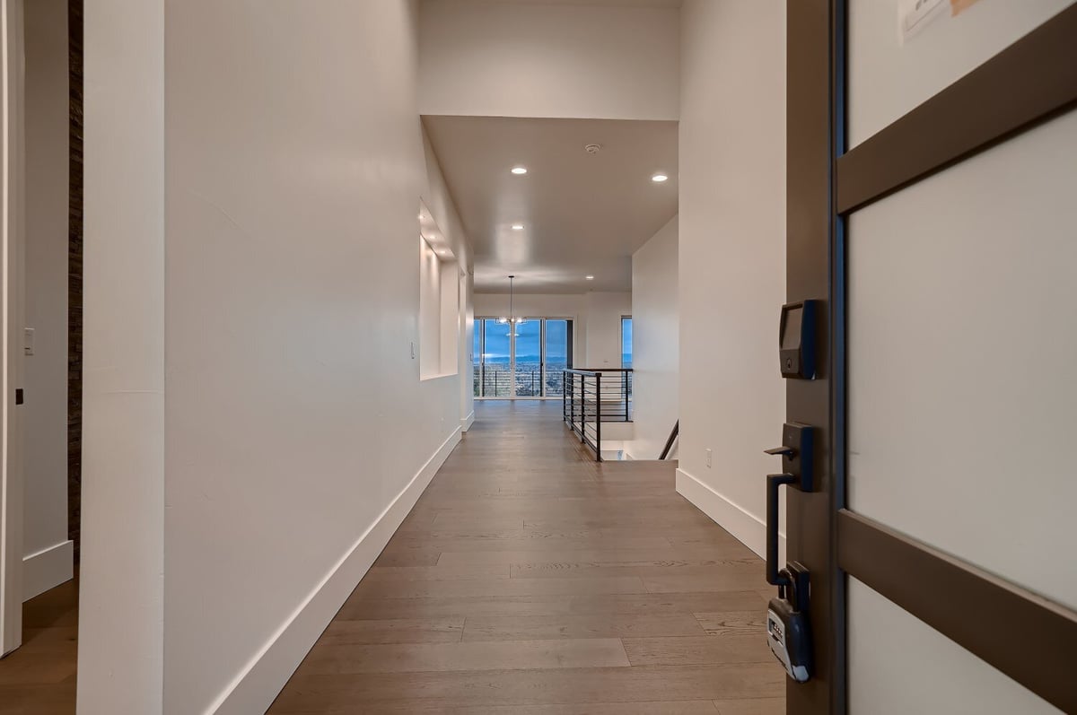 Long shot of the pathway from the room door with a foyer and railings in a house by Sheffield Homes in Arvada, CO