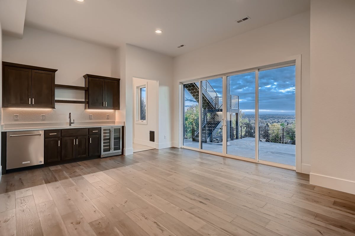 Lower-level wet bar with large sliding doors for outside views in a custom home by Sheffield Homes in Arvada, CO