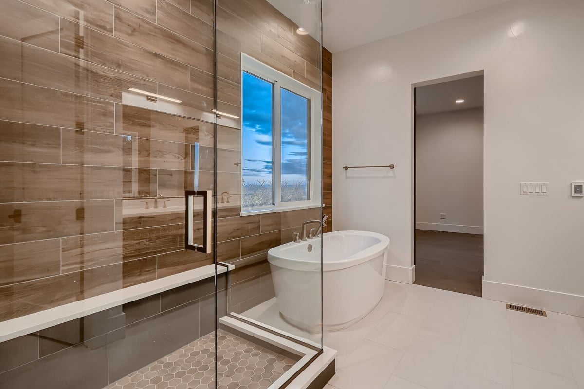 Side view of the primary bathroom with a shower room and bathtub in a custom home by Sheffield Homes in Arvada, CO