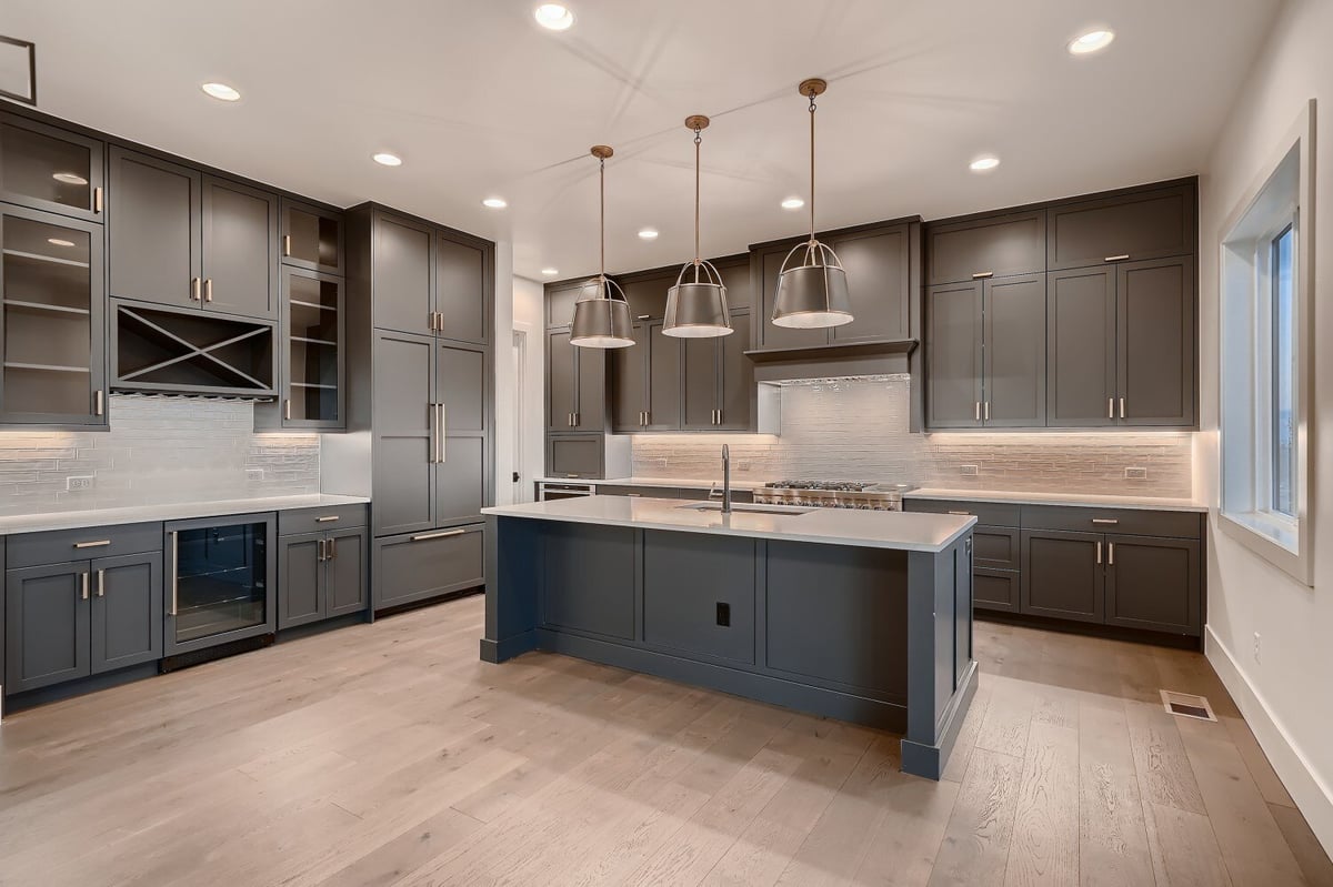 Spacious kitchen with modern design, island, sleek cabinetry, and elegant lighting by Sheffield Homes in Arvada, CO