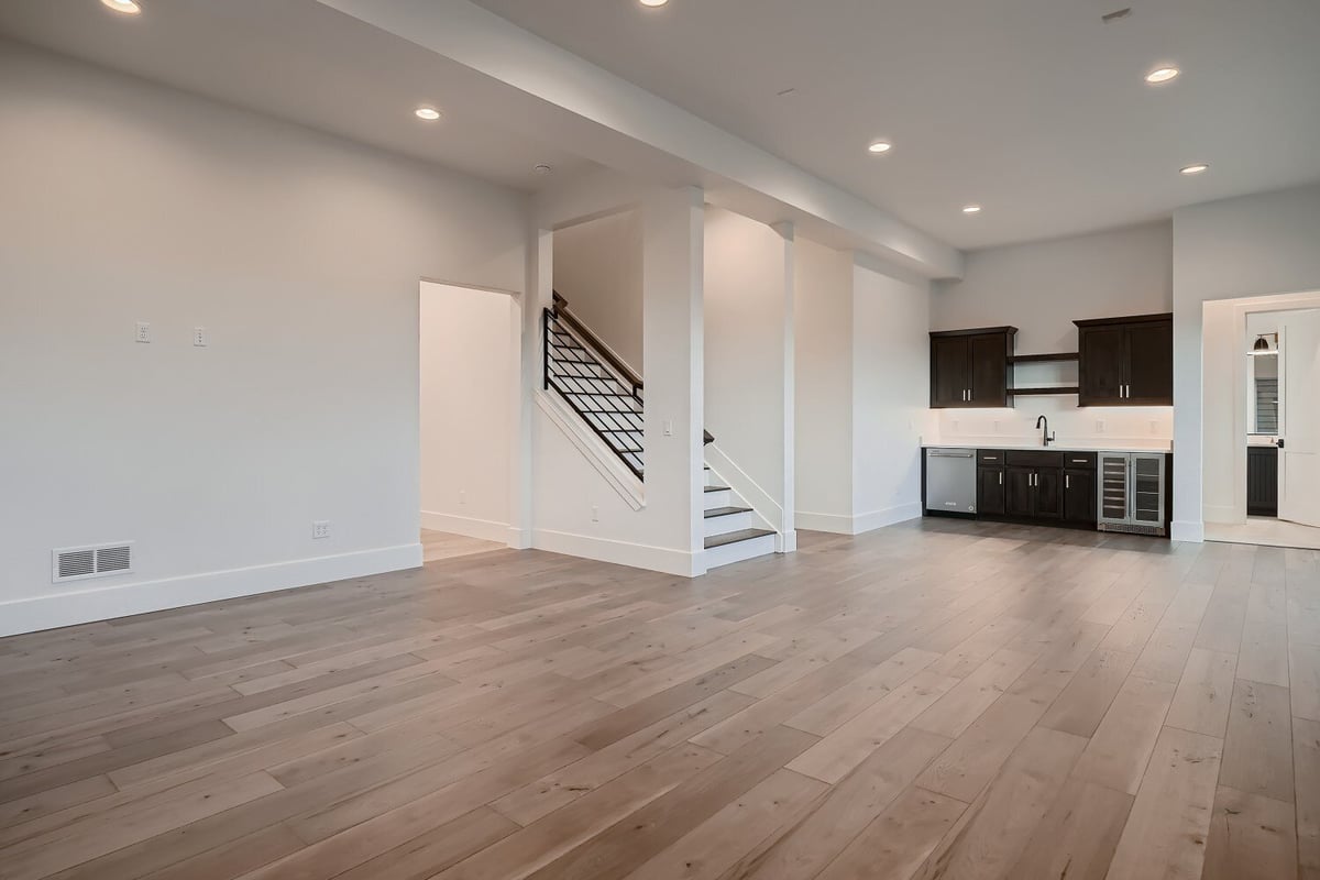 Spacious living room with a corner vanity and sleek foyer with railings in a house by Sheffield Homes in Arvada, CO