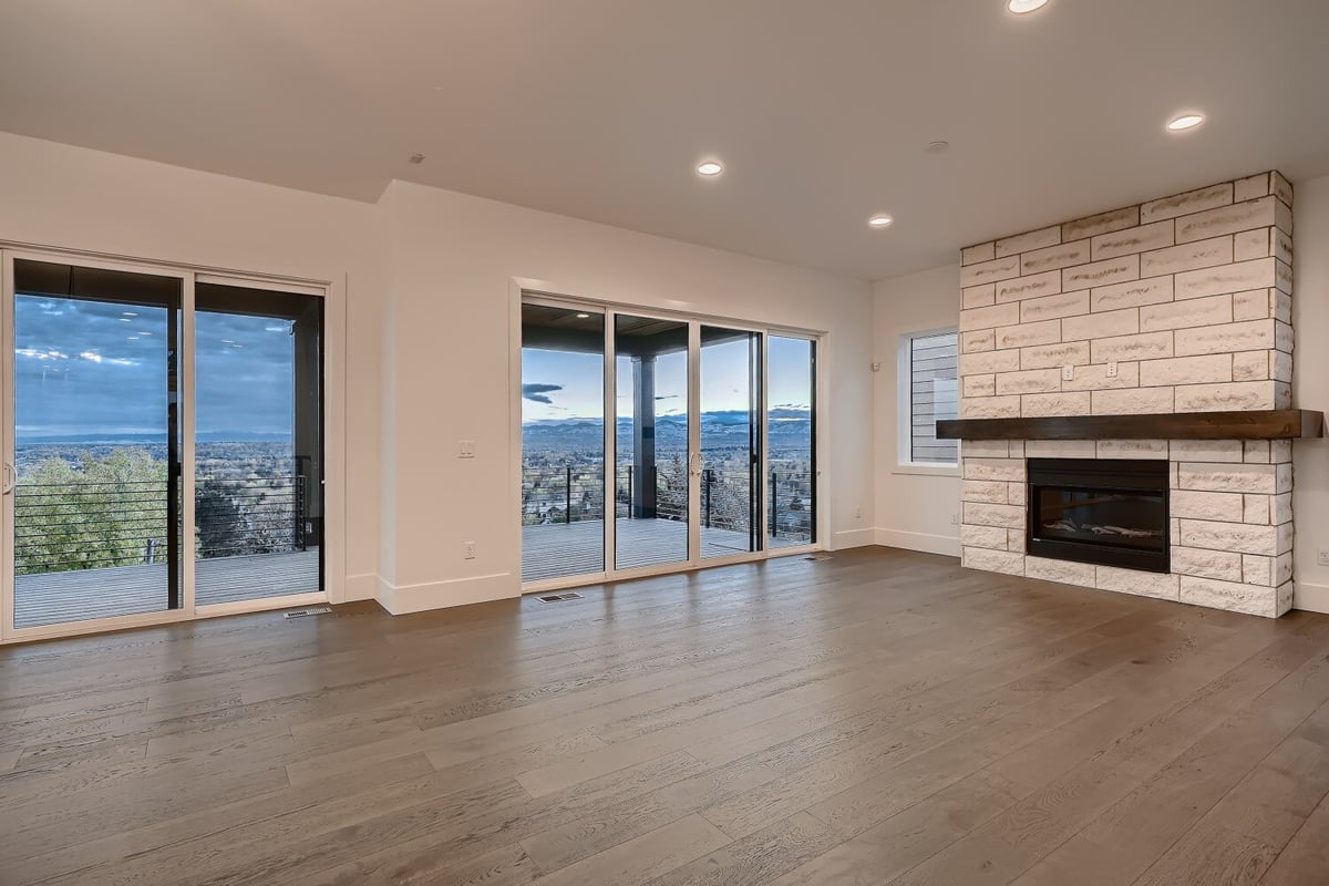 Spacious living room with floor-to-ceiling sliding doors and a feature wall with fireplace by Sheffield Homes in Arvada, CO