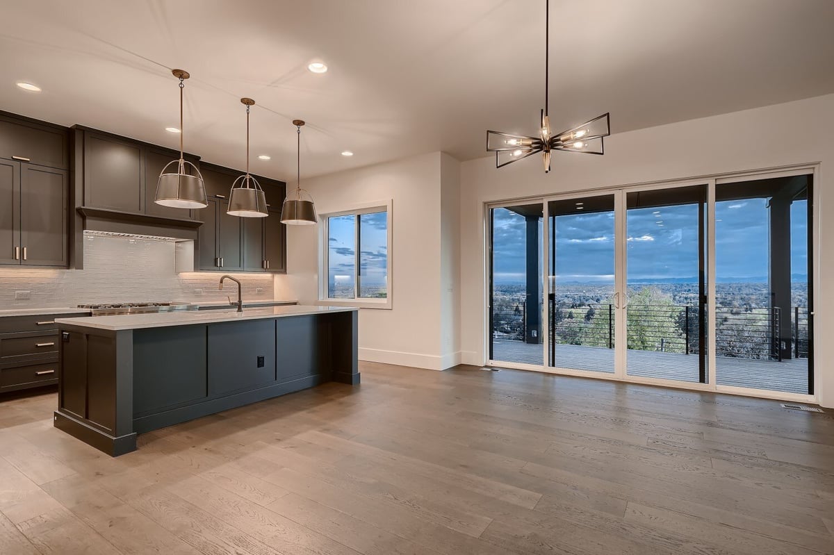 Spacious living room with large sliding doors and an open kitchen island by Sheffield Homes in Arvada, CO