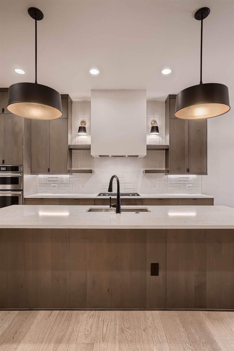 Closeup of an elegant kitchen island with sleek, minimalistic colors in a house by Sheffield Homes in Arvada, CO