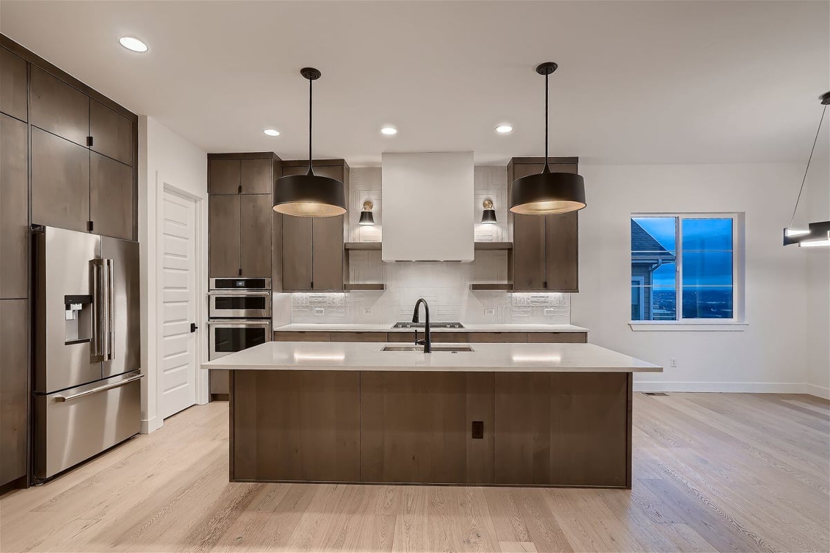 Modern kitchen with an island and stainless steel appliances in a house by Sheffield Homes in Arvada, CO