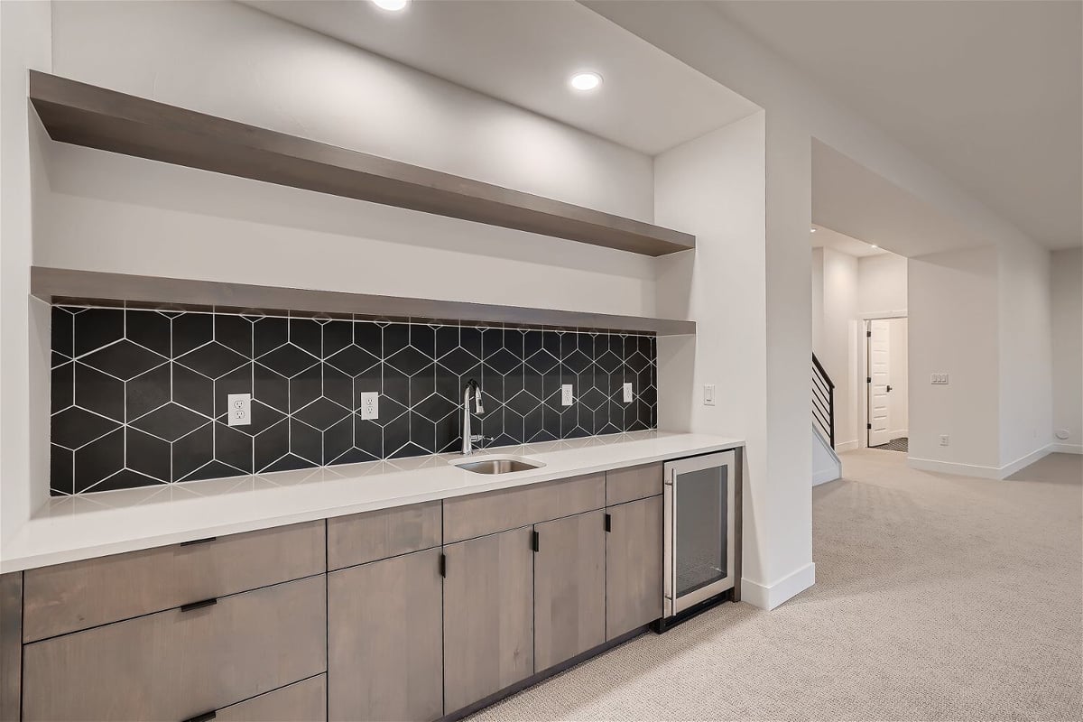 Modern lower-level wetbar with sleek cabinetry and cubic wall design in a custom home by Sheffield Homes in Arvada, CO