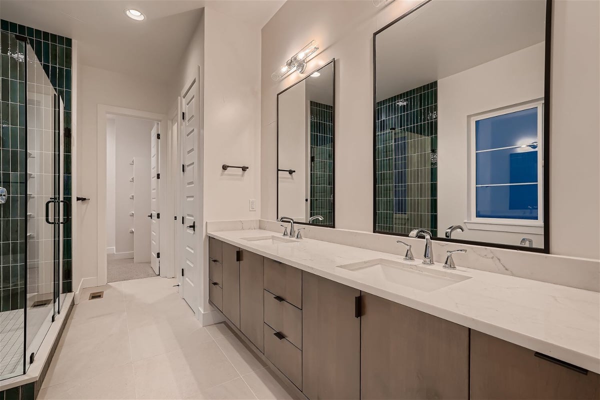 Primary bathroom with modern dual vanities and a shower room in a custom home by Sheffield Homes in Arvada, CO