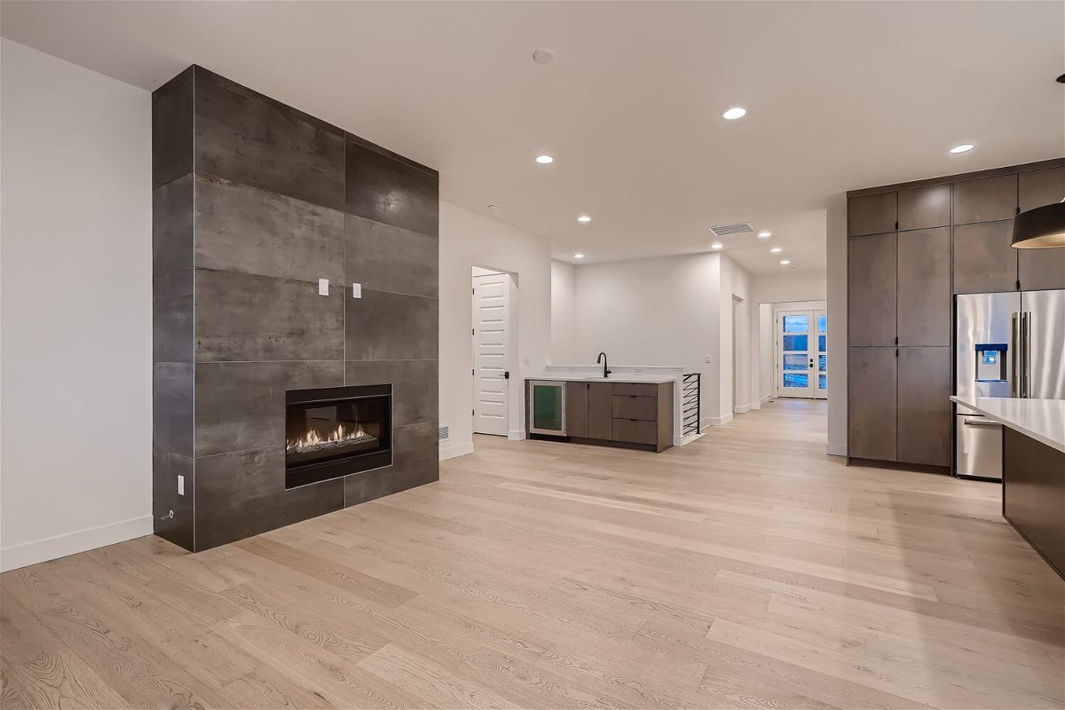 Spacious living room with a modern fireplace and a sleek vanity by Sheffield Homes in Arvada, CO