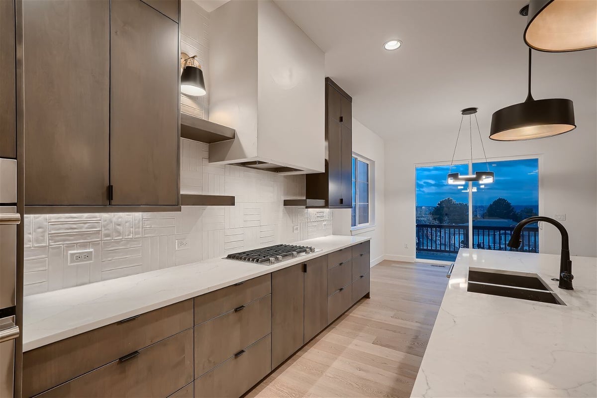 Spacious open kitchen with modern wooden cabinets, stoves, and an island by Sheffield Homes in Arvada, CO