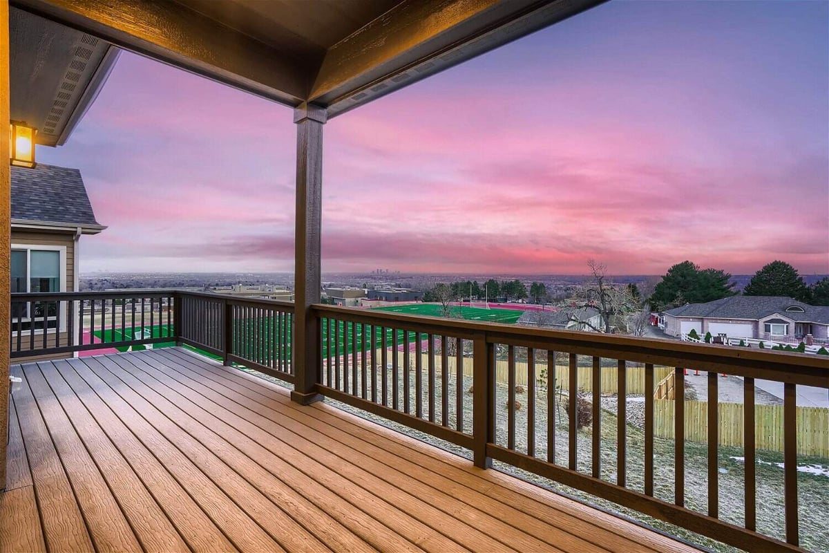 Top deck with wood fencing and flooring, offering beautiful views in a custom home by Sheffield Homes in Arvada, CO