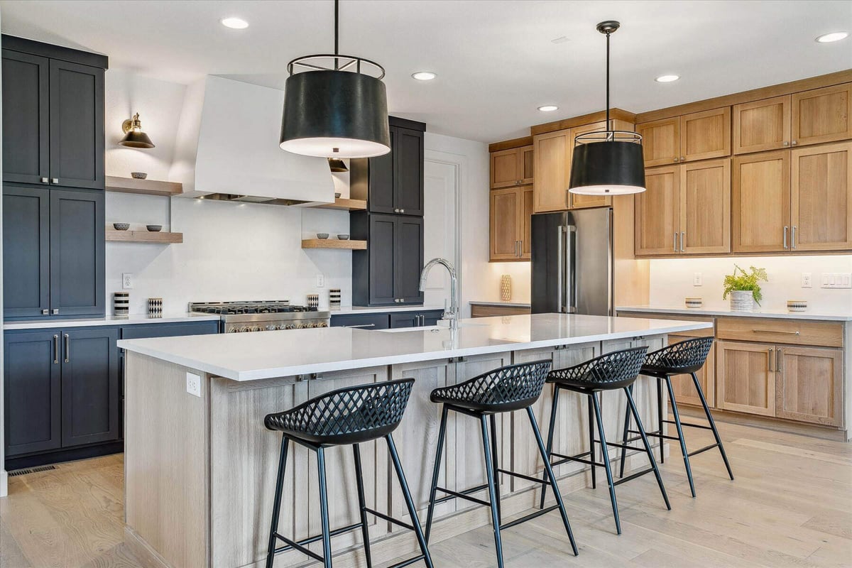 A beautiful kitchen island with a smooth top, and four aligned dining seats in a custom home by Sheffield Homes in Arvada, CO