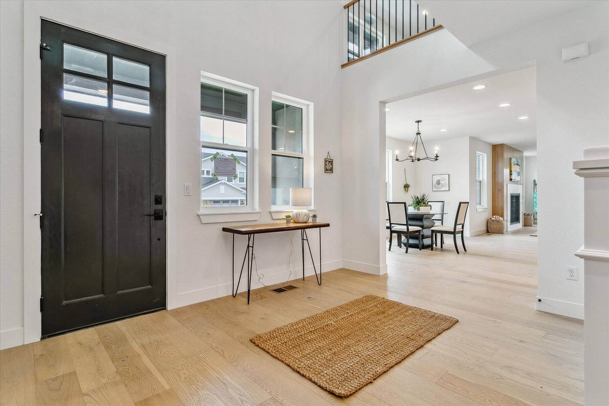 A living room corner with a side table, black door, and a bamboo rug on the floor built by Sheffield Homes in Arvada, CO