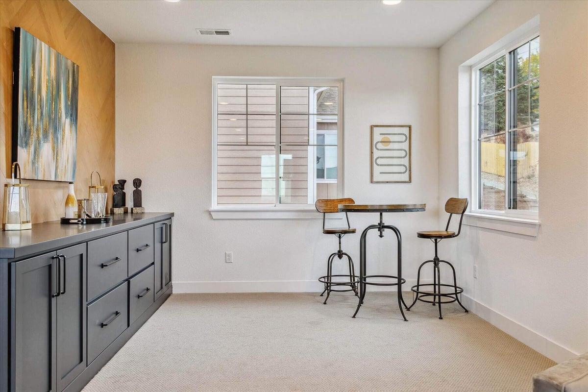 Bar area with a two-person table and sliding windows for outside views in a custom home by Sheffield Homes in Arvada, CO