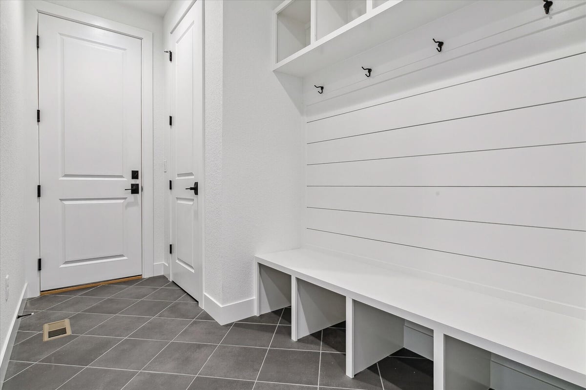 Bathroom detailing with access doors and a bench beneath clothes hooks in a custom home by Sheffield Homes in Arvada, CO