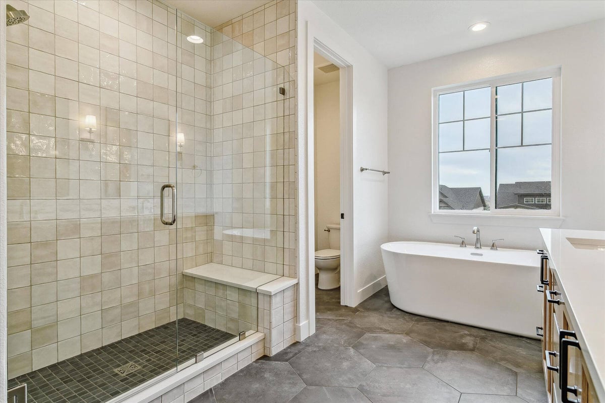 Bathroom with a shower room, bathtub, and separate toilet room in a custom home by Sheffield Homes in Arvada, CO