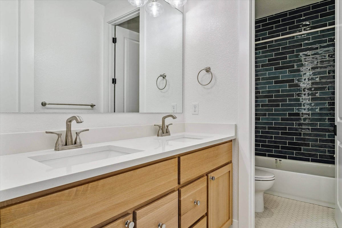 Closeup of sleek, modern vanities inside the bathroom, adjacent to the toilet room - by Sheffield Homes in Arvada, CO