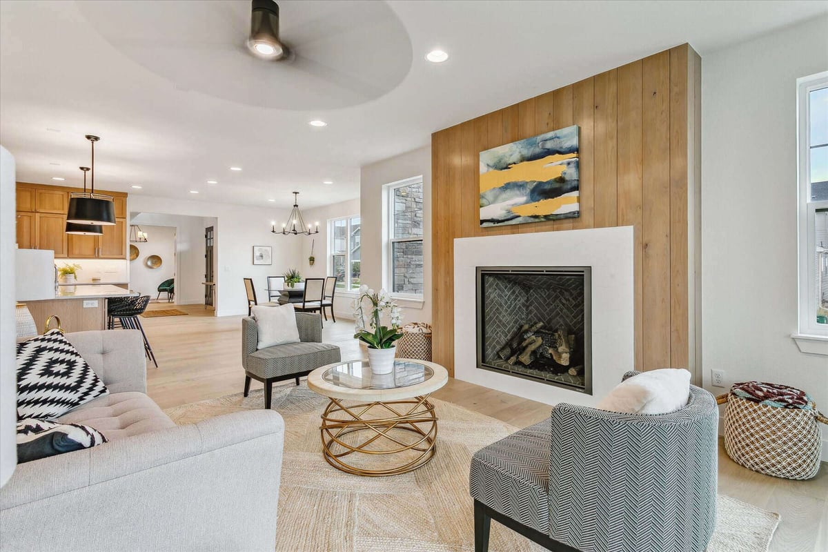 Family room with sofa sets, a coffee table, and a wall-mounted fireplace in a custom home by Sheffield Homes in Arvada, CO