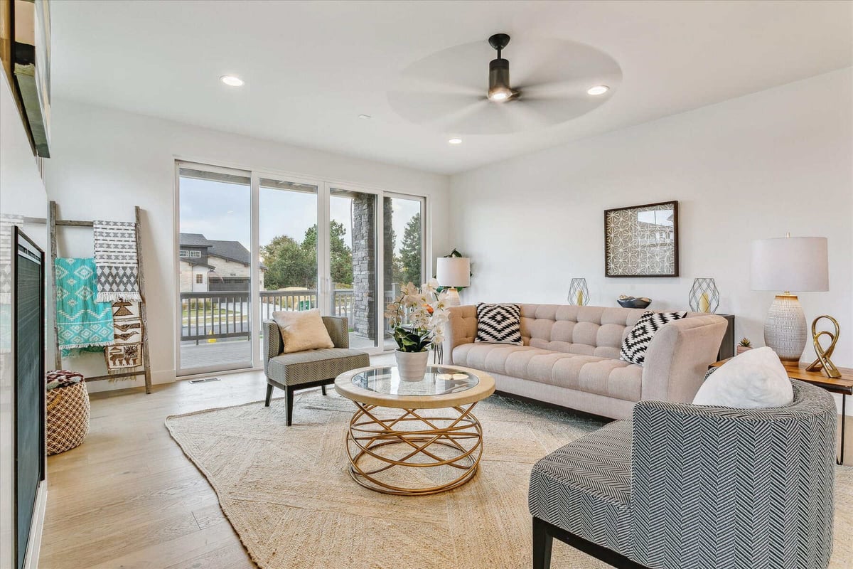 Family room with sofas, a coffee table, and large sliding doors for outdoor views in a house by Sheffield Homes in Arvada, CO