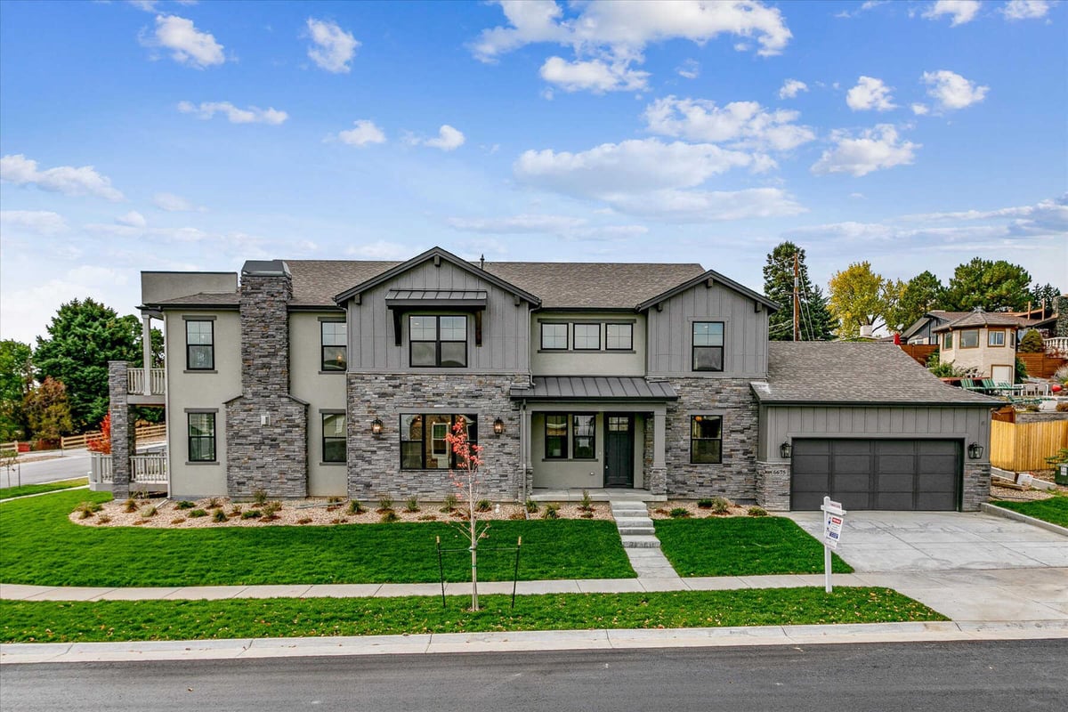 Front exterior view of a large custom home with a lawn, built by Sheffield Homes in Arvada, CO